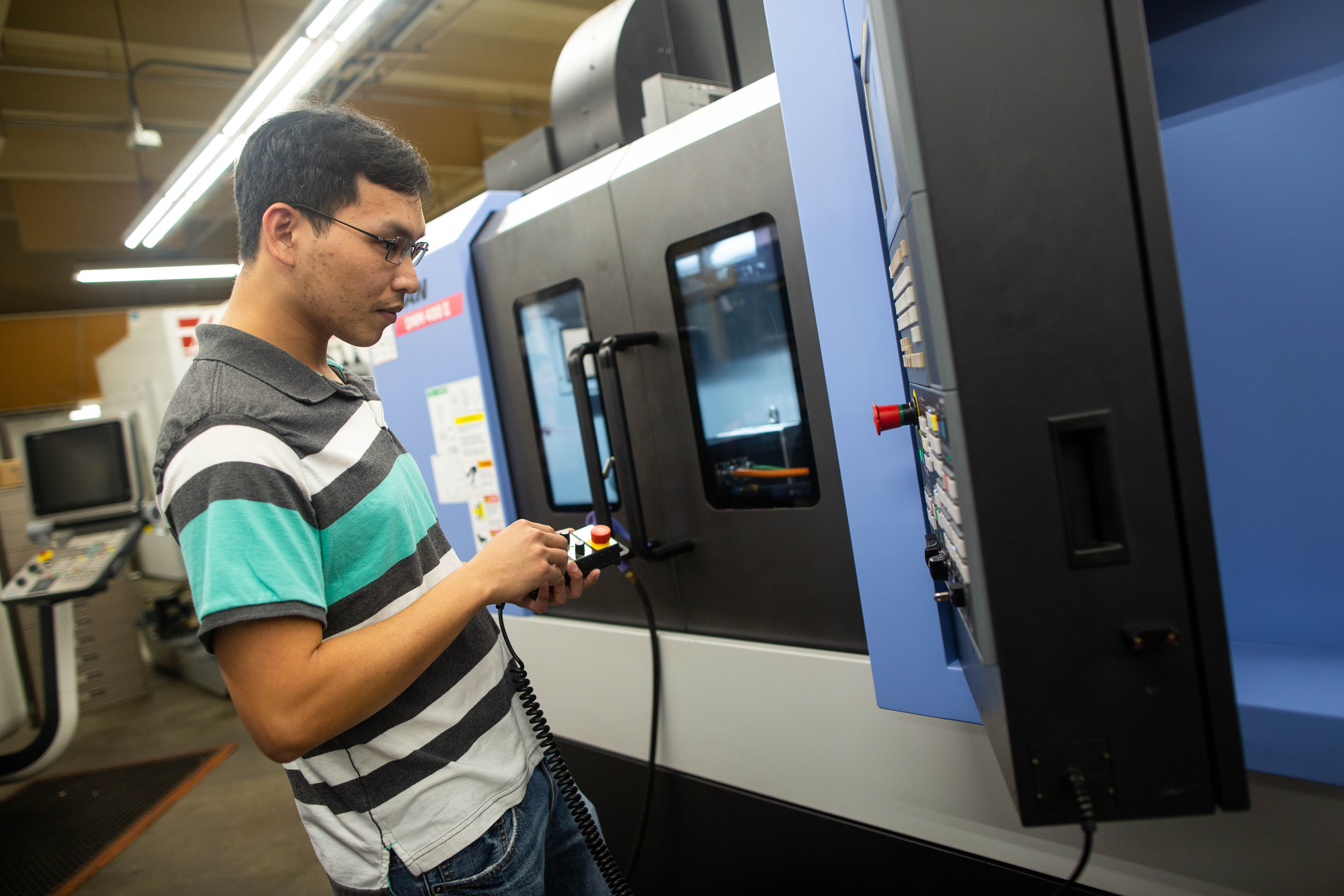 student operating CNC machine