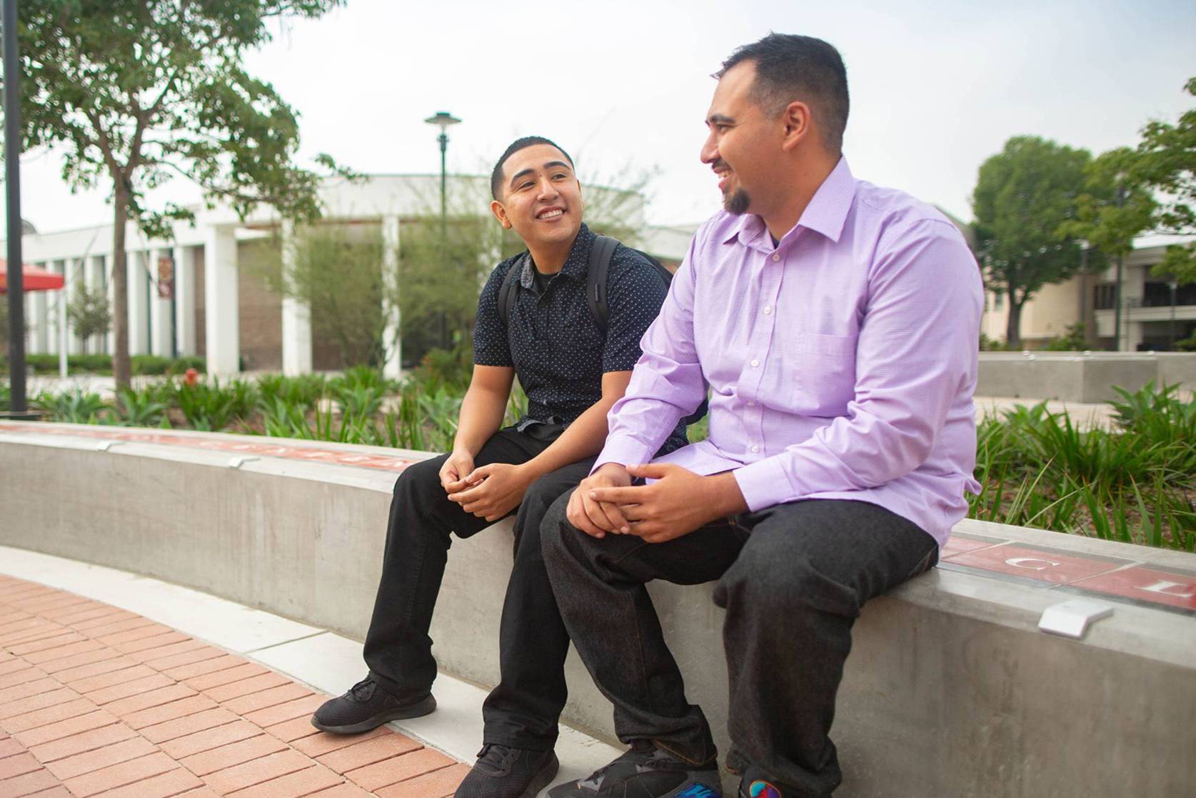 two students speaking with each other in center of campus