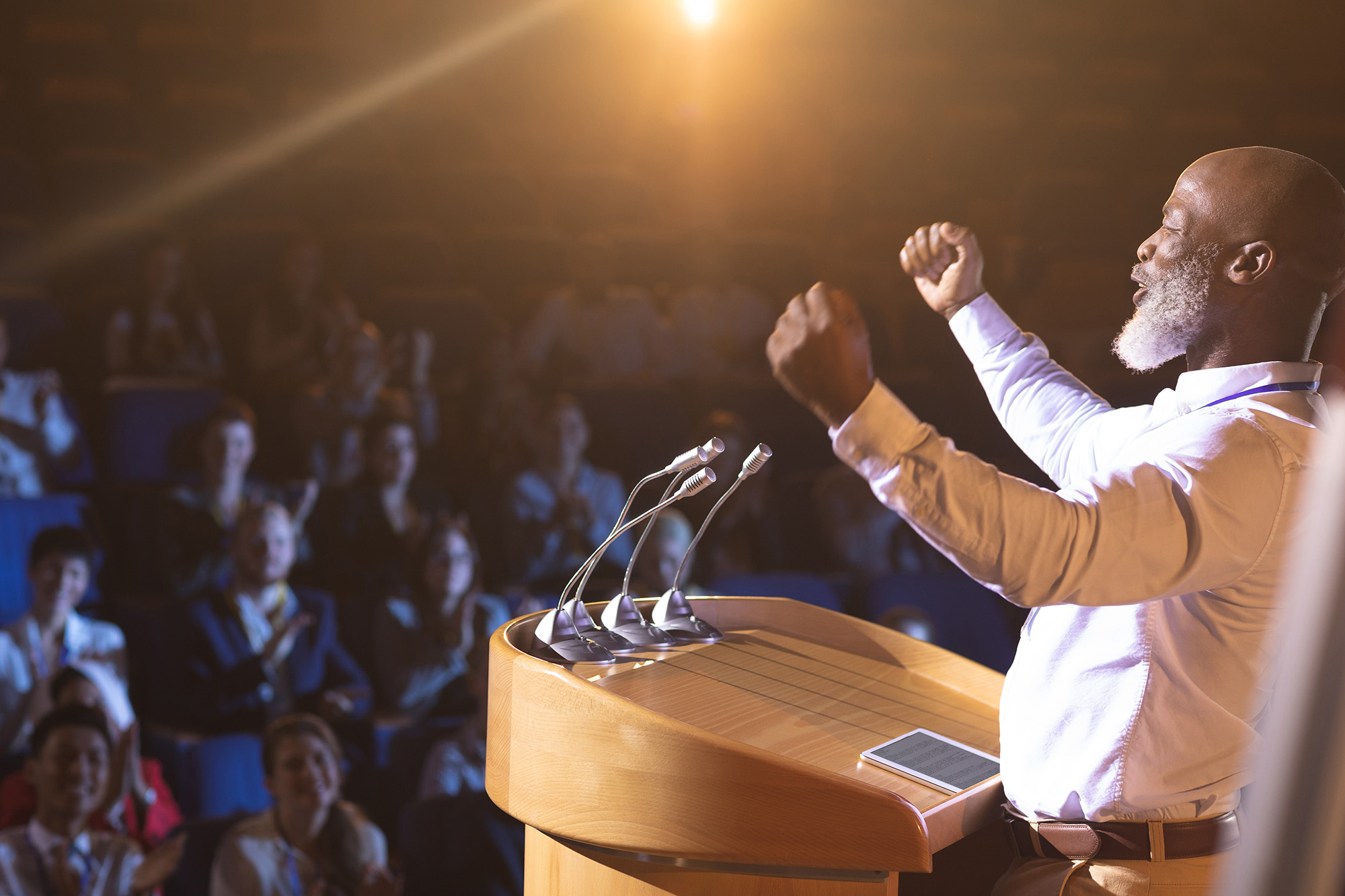 cartoon of a male giving a speech in front of a large audience