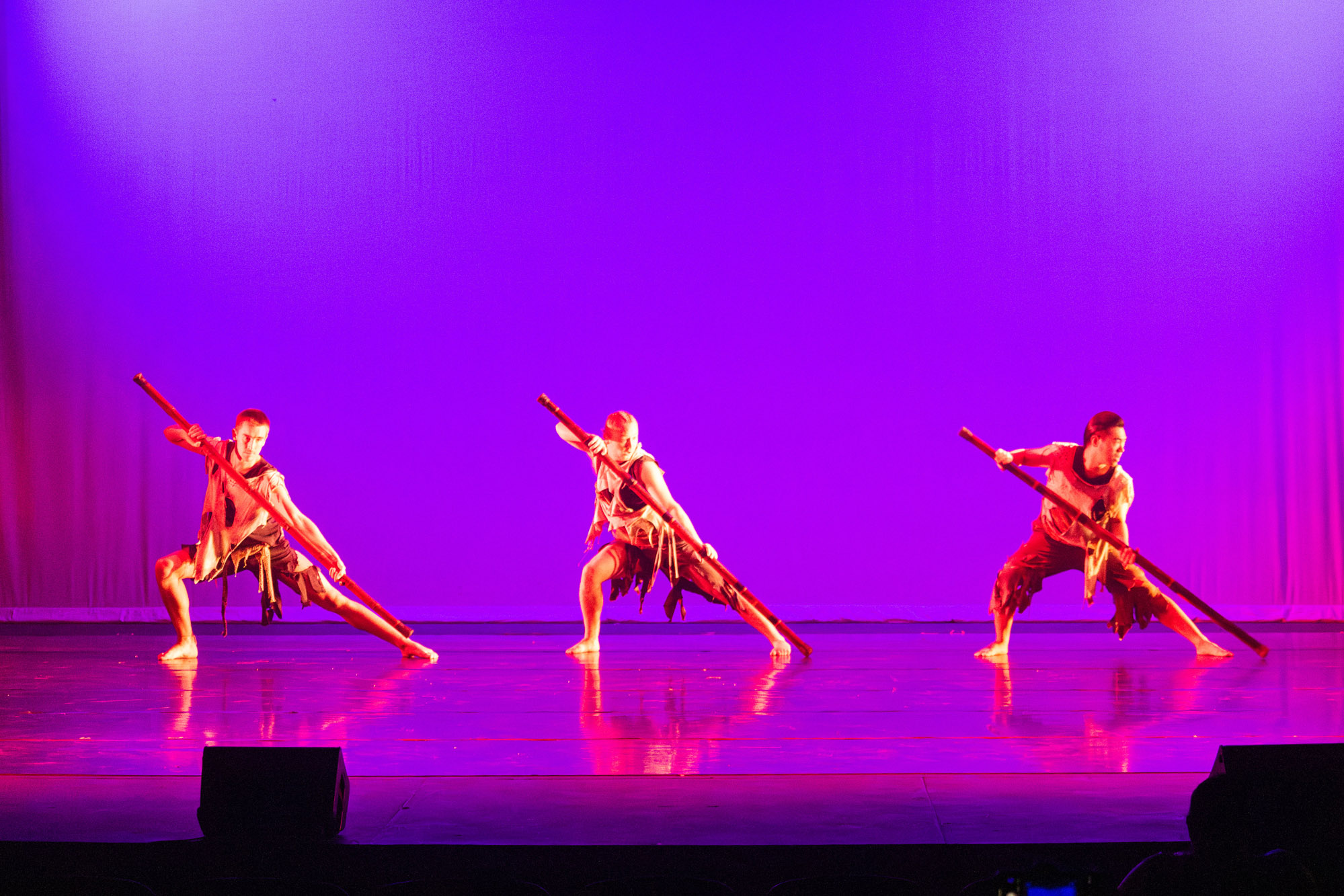 three male in polynesian outfit and holding wooden staffs dancing at Body Monologues 2025