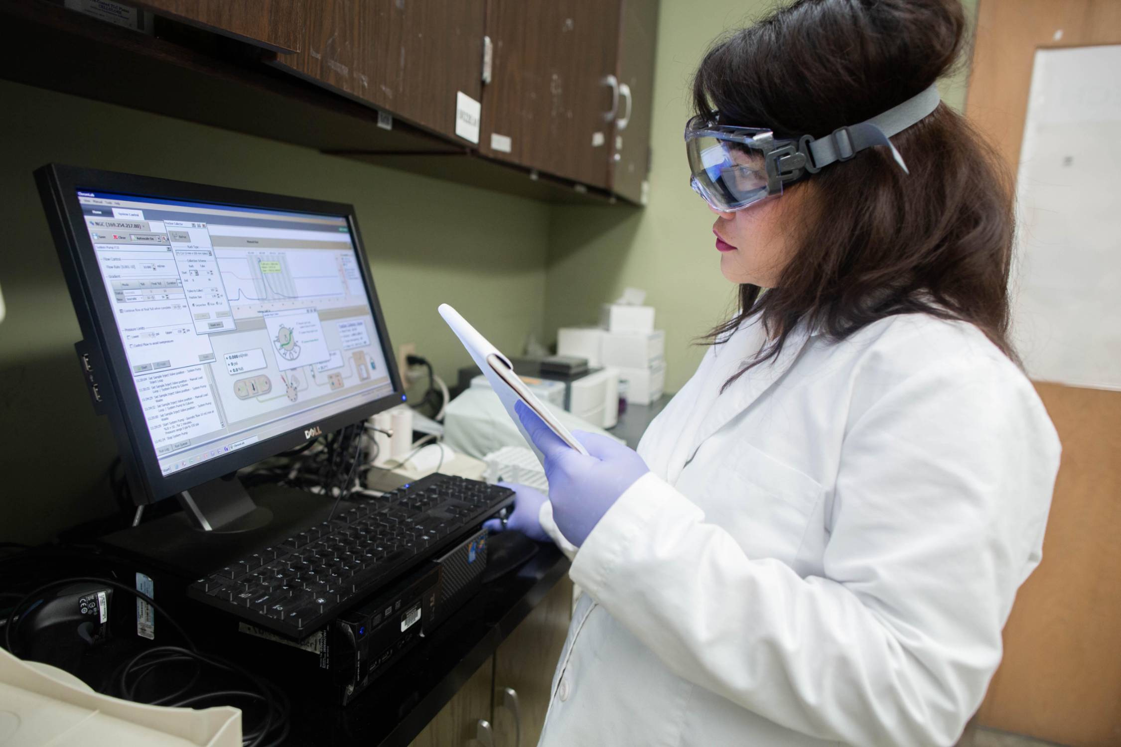 female pharmaceutical tech student analyzing a lab sample on a computer
