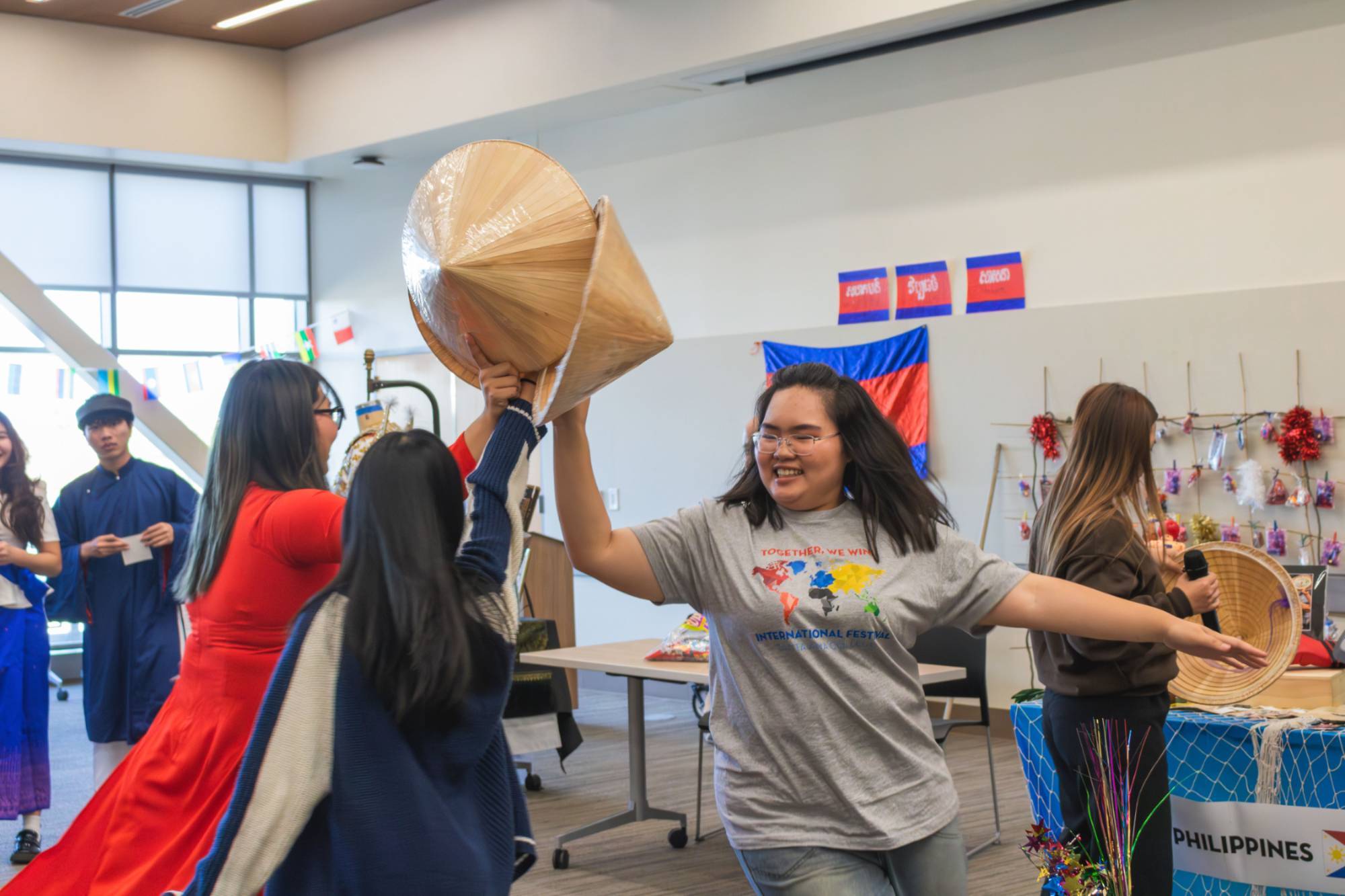 Three asian female students playing with traditional vietnamese hat