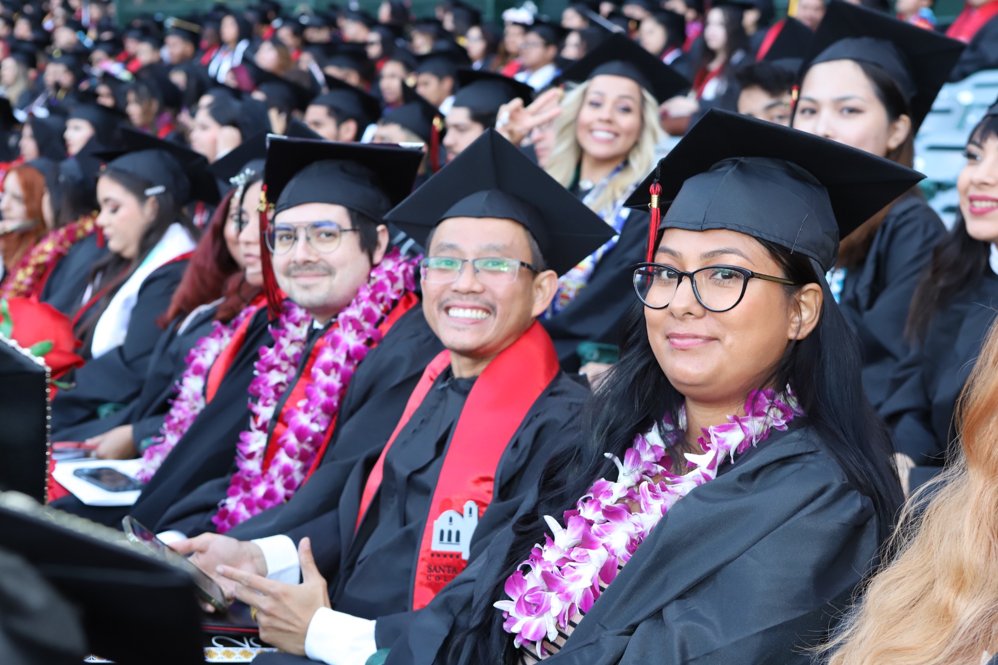 students in graduation gown sitting