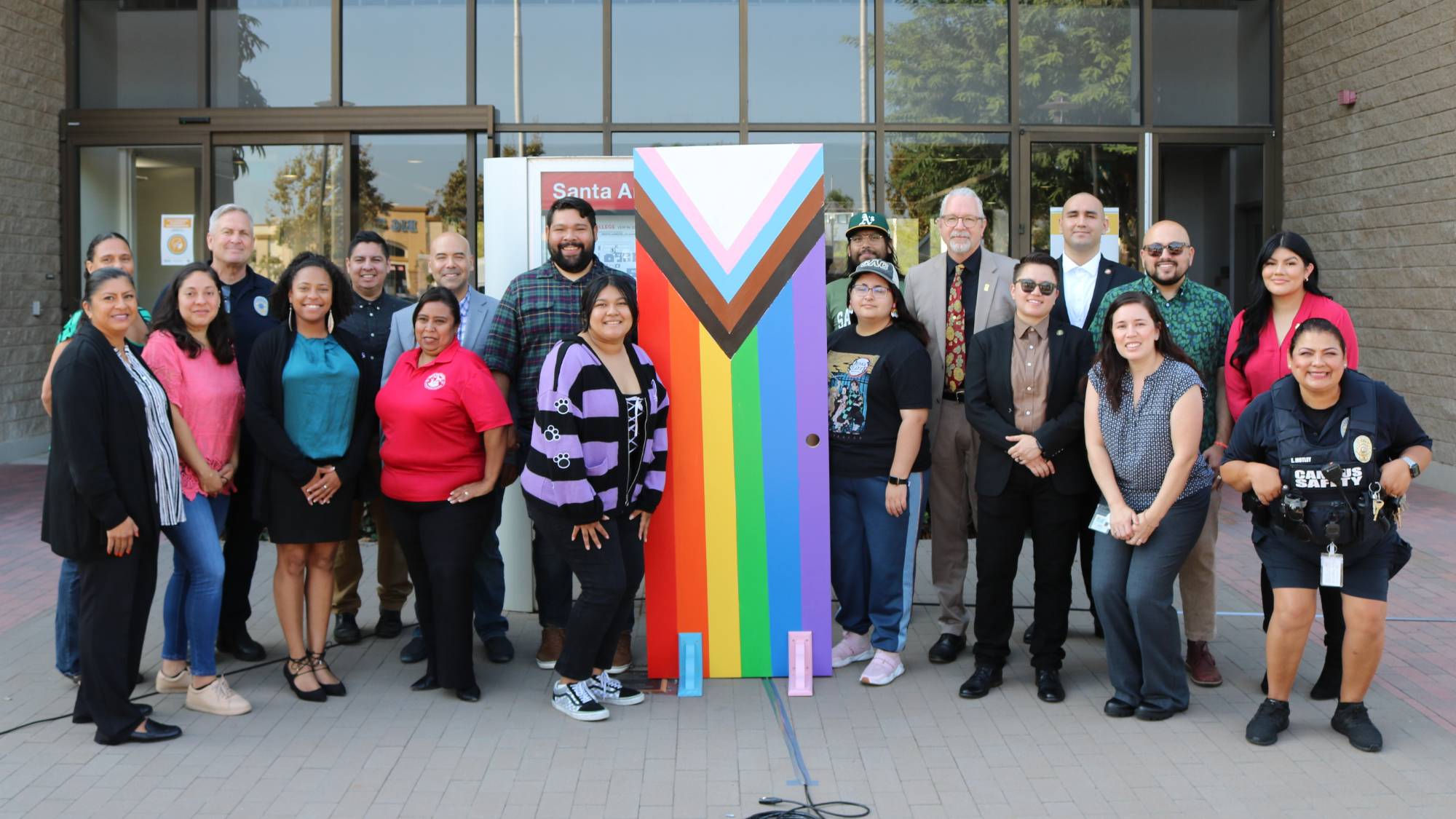 SAC Pride Students Pose Next to Flag