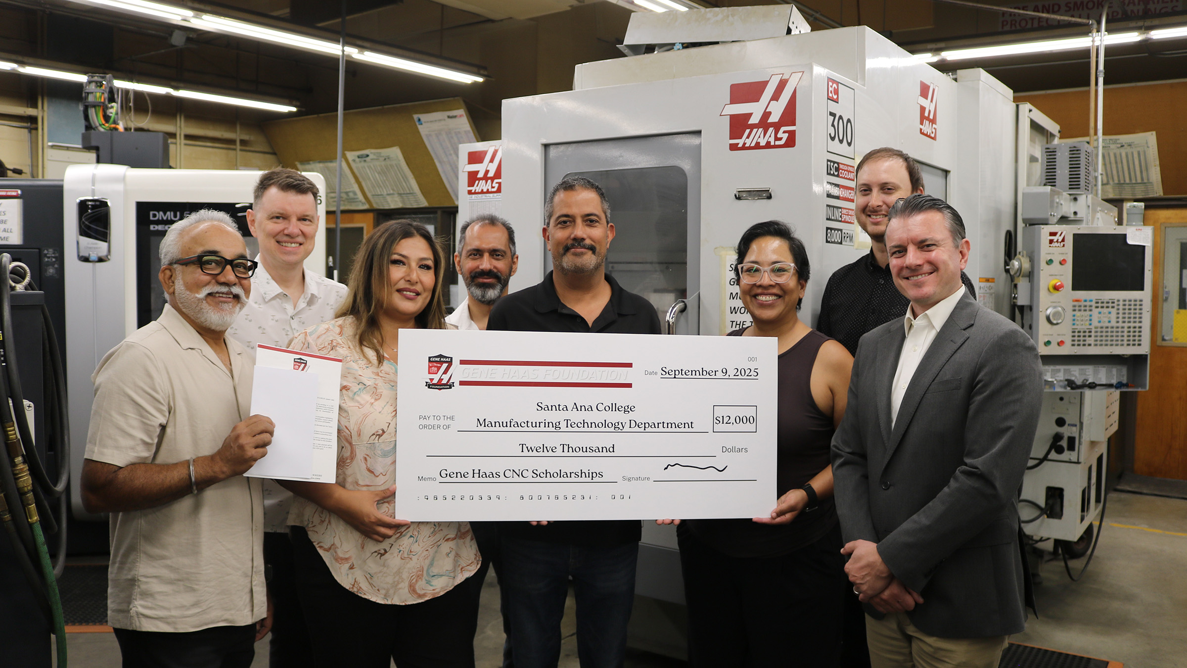 SAC Foundation and MT members hold up giant check alongside Haas Foundation representative