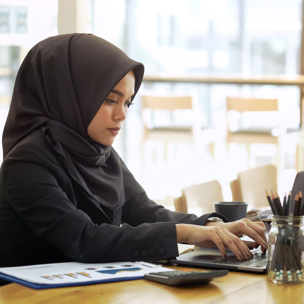 Female accountant wearing a hijab working successful finance job with skills learned at Santa Ana College