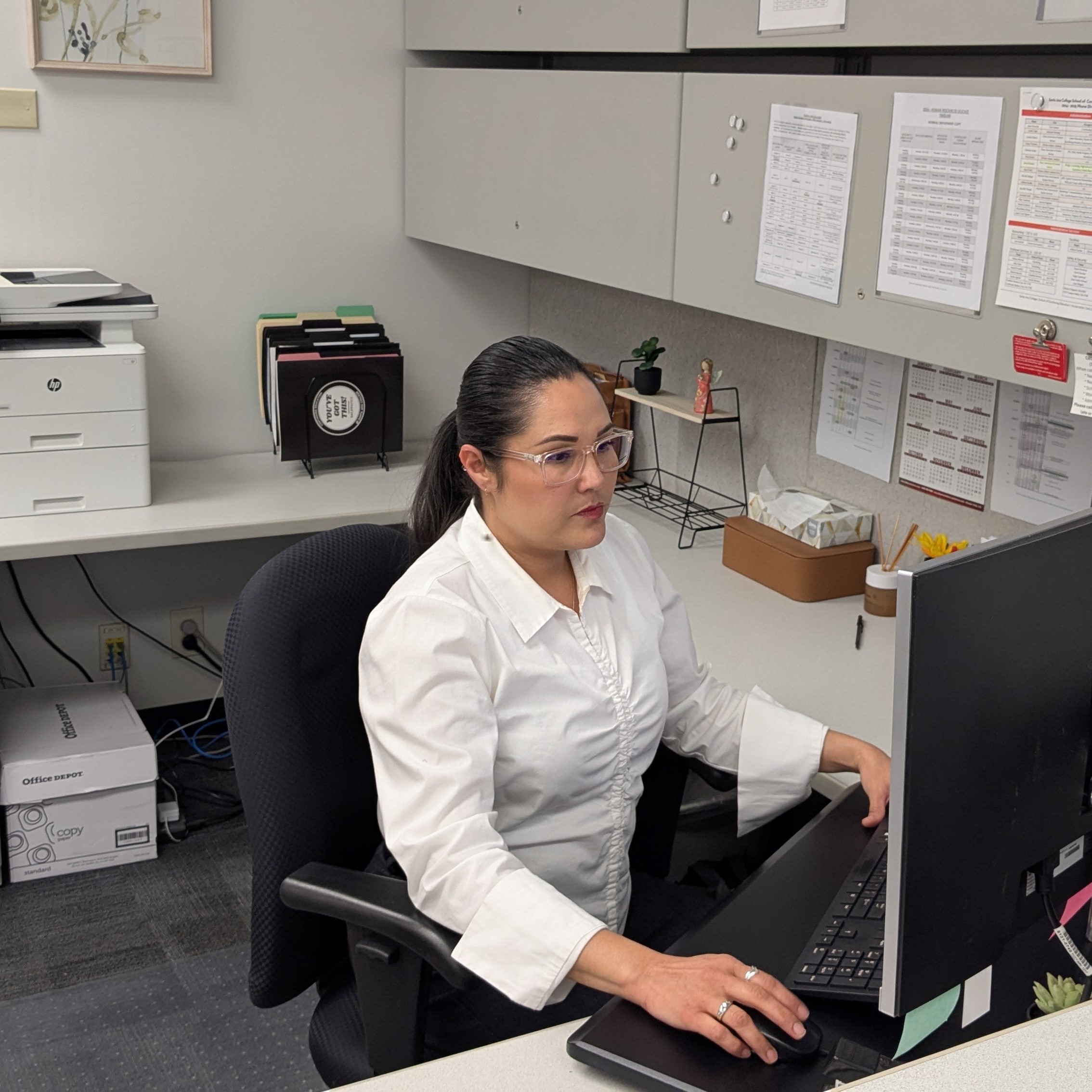 Focused woman working as an administrative assistant  after taking free classes at Santa Ana College