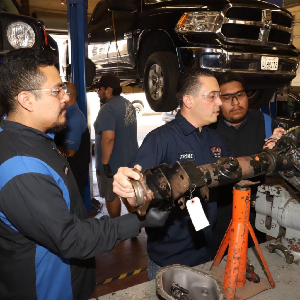 Men repairing truck in auto repair shop after gaining career skills with automotive technology, systems, engines, and transmissions program at Santa Ana College