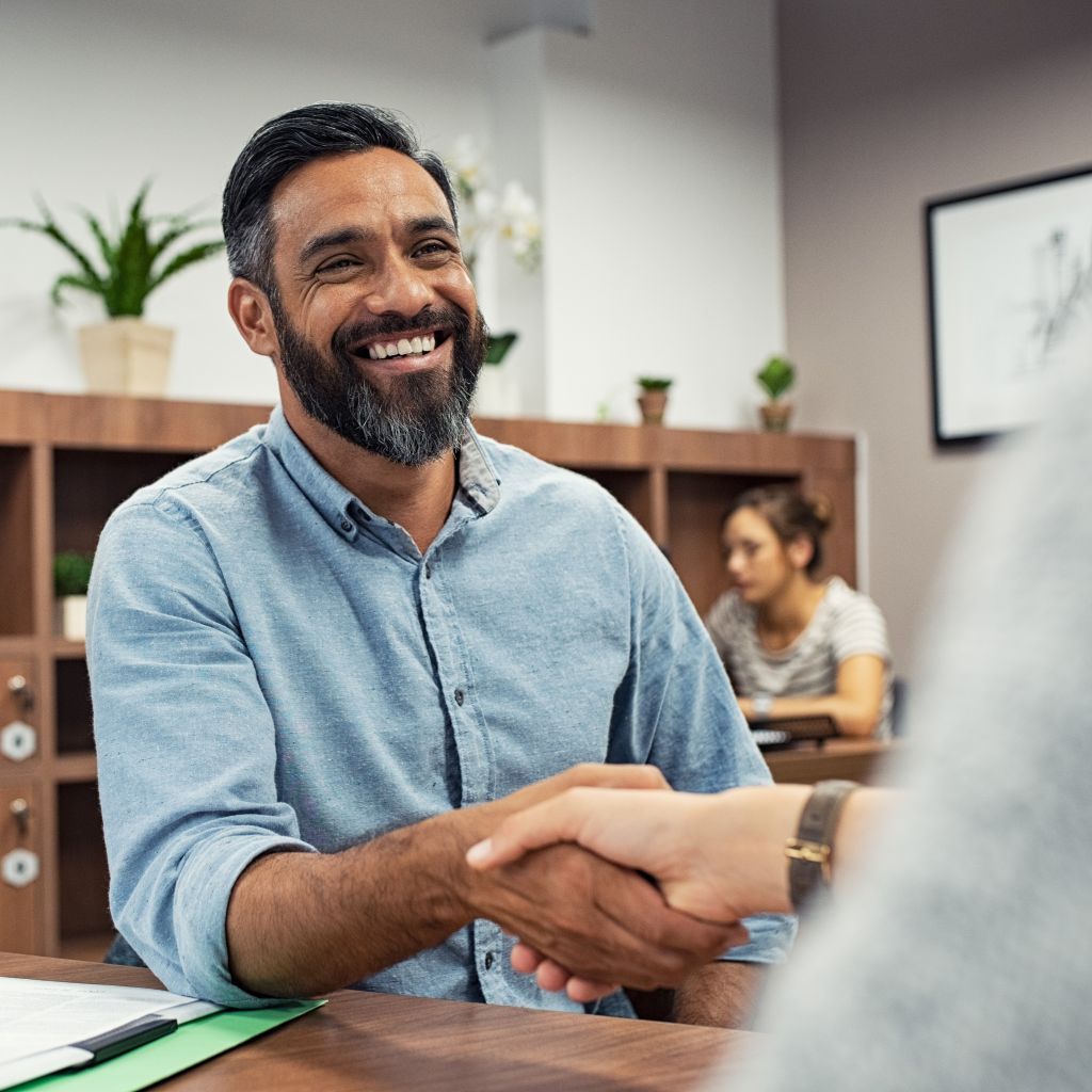 Man smiling in business meeting after becoming a certified global business professional at Santa Ana College