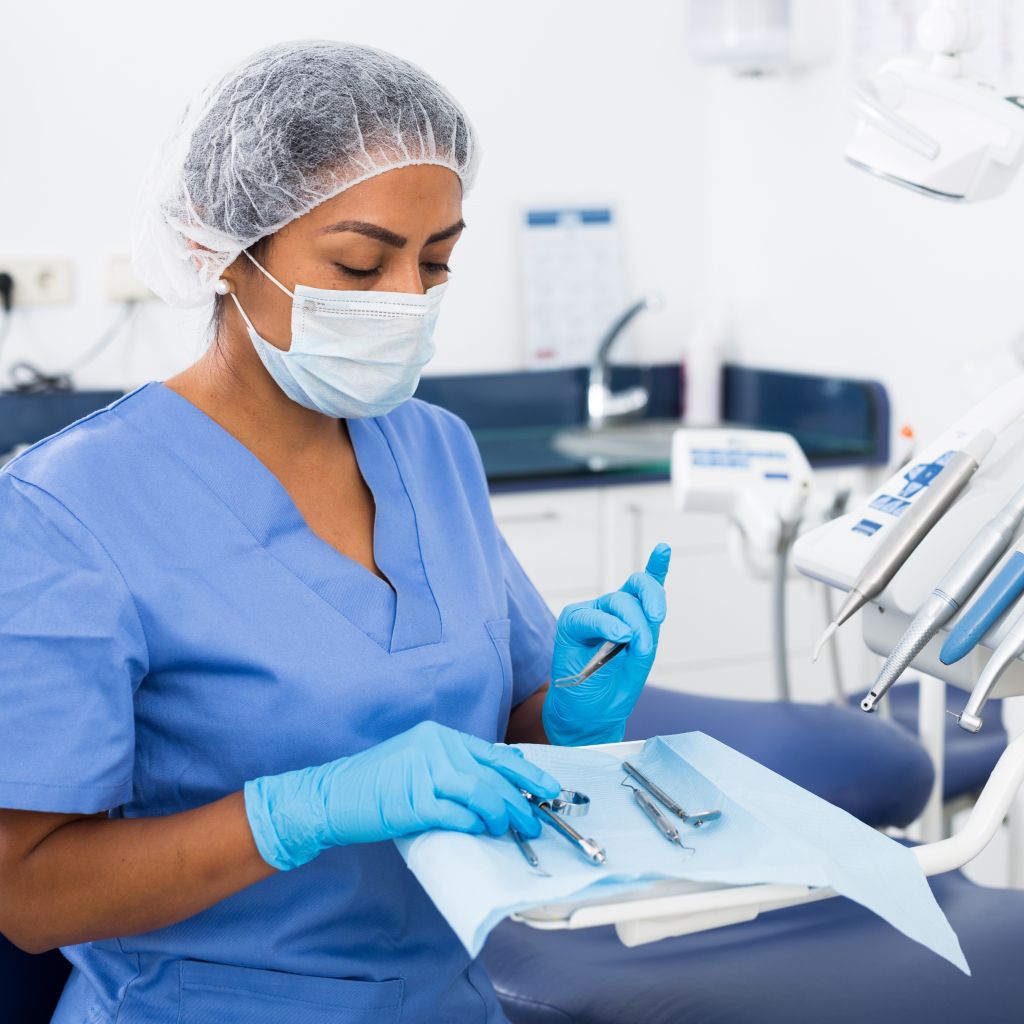 Focused woman working as a dental assistant after taking free classes at Santa Ana College