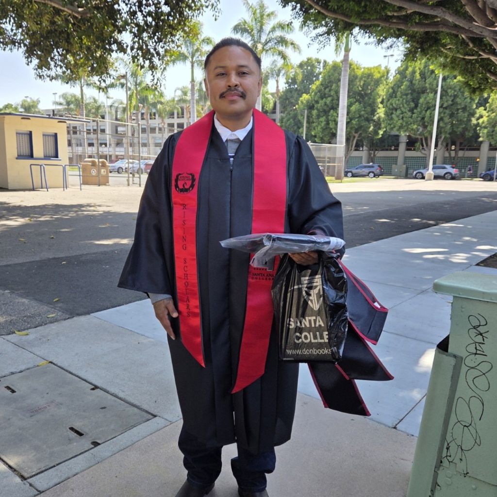 Latino man in graduation robe after completing high school through Continuing Education in Santa Ana, near Anaheim, Irvine, and Tustin.