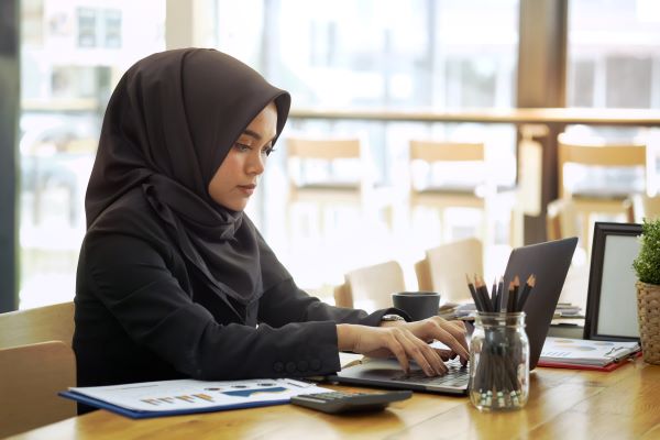 Female accountant wearing a hijab working successful finance job with skills learned at Santa Ana College