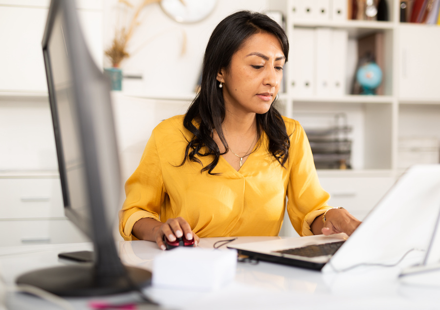 Focused woman working as an administrative assistant  after taking free classes at Santa Ana College