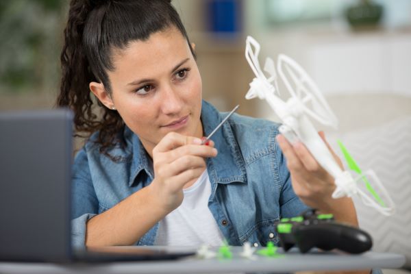 Woman repairs drone using skills gained from free drone classes in Santa Ana, near Anaheim, Irvine, and Garden Grove.