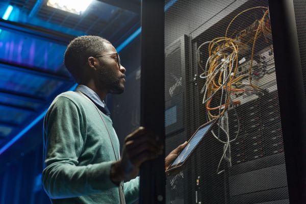 Man inspecting computer data server with confidence because of free IT Basics classes in Santa Ana, near Anaheim, and Irvine.