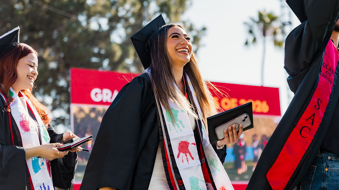 Female latina student smiling and walking at graduation